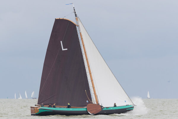 Traditioneel skutsje met bruine zeilen varend op het IJsselmeer tijdens zeiluitje