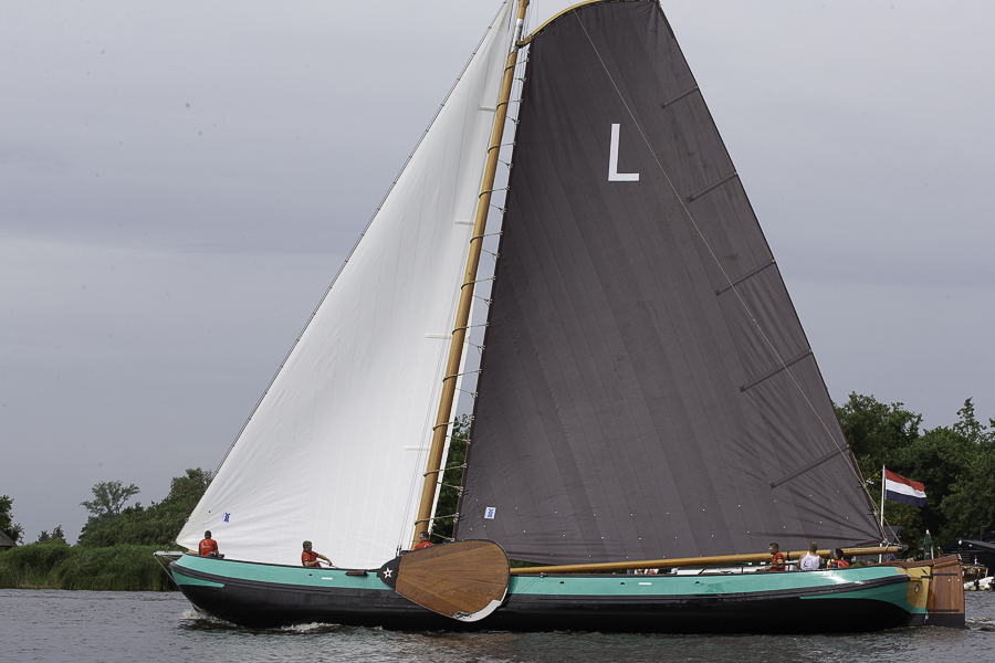 Traditioneel skutsje met bruin zeil vaart op het IJsselmeer tijdens zeiluitje