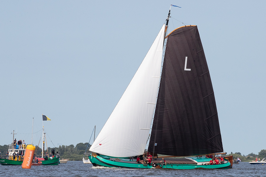Traditioneel skutsje met bruine zeilen vaart op het IJsselmeer tijdens zonnige dag